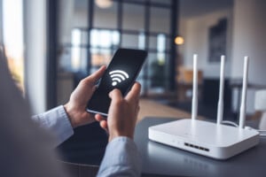 Un smartphone affiche Wi‑Fi et 5G près d’une box Internet